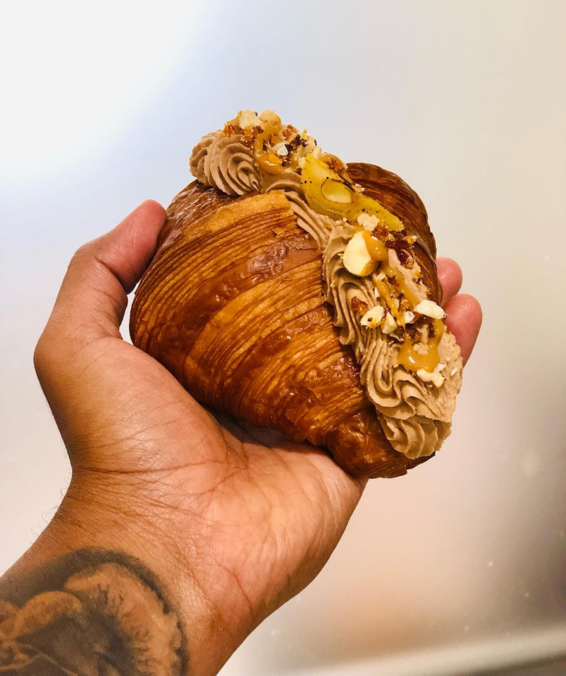 Hands holding a freshly laminated viennoiserie pastry